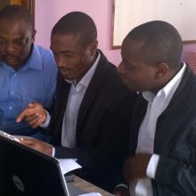 three delegates working at a computer during an oa policy formulation workshop in 2015