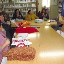 Women meeting in the library with their sewing and knitting. 