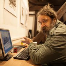 A homeless person learning how to use a computer in the library.