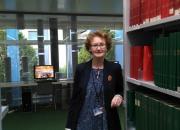 Teresa Hackett next to a bookshelf in the WIPO library.