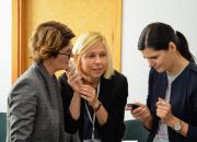 Three workshop participants listening to audio devices for print disabled people.