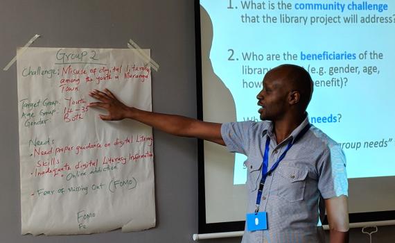 Raymond Chepkwony of Kenya National Library Service (KNLS) gives feedback from newsprint during group discussion.