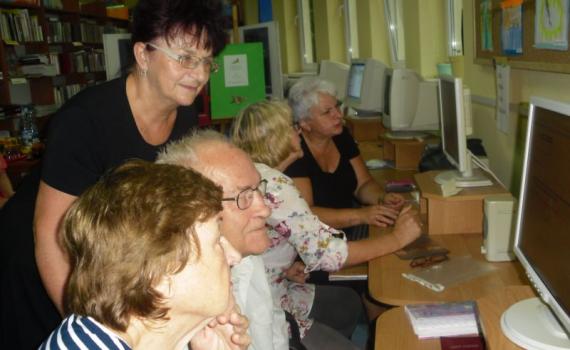 INTERNET ABC: Seniors learn internet skills to serve their daily needs in Twardogóra Public Library. A group of senior people learning internet skills in the library.