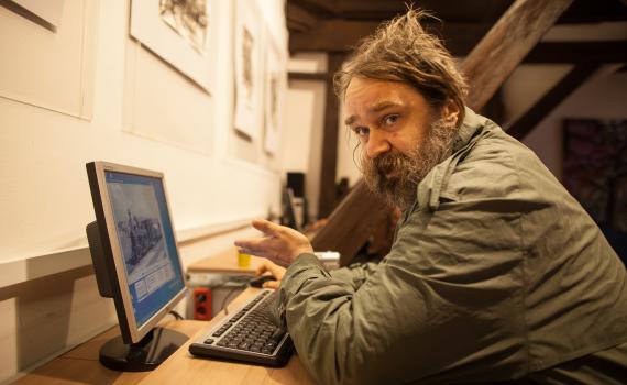 A homeless person learning how to use a computer in the library.