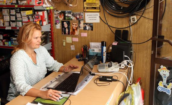 A successful jobseeker at her place of employment in an automobile sales outlet.