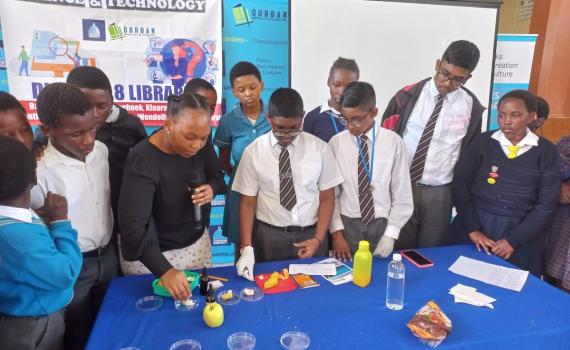 A group of youth mixing chemicals in glass dishes. 
