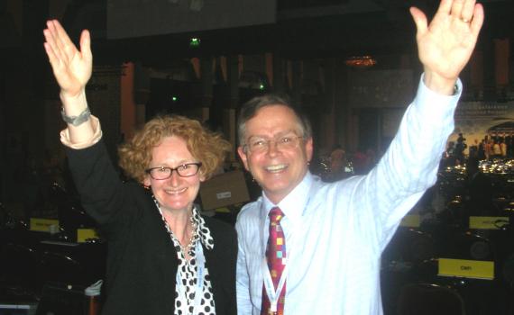 Happy photo of EIFL's Teresa Hackett and Bookshare's Jim Fruchtermann mark adoption of the treaty in Marrakesh, each with an arm raised in celebration. 